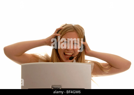18 Jahre alte Frau hinter einen Laptop mit einem Kopfhörer, lachen, reißen ihr Haar Stockfoto