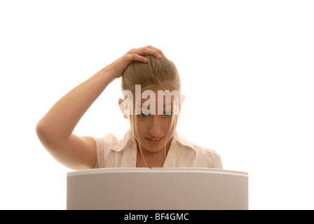 18 Jahre alte Frau hinter einem Laptop, reißen ihr Haar Stockfoto