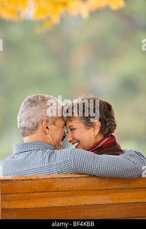 African paar umarmt auf Parkbank Stockfoto