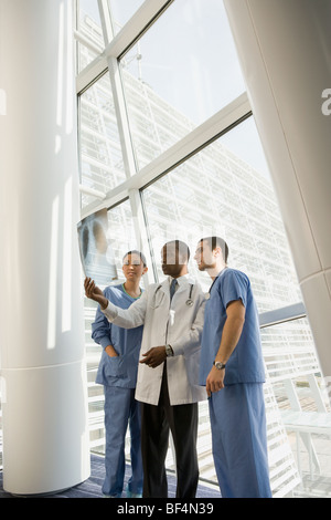 Multi-ethnischen Arzt und Krankenschwestern, die Überprüfung der Röntgen-Fenster Stockfoto