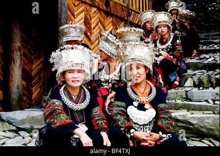 Miao junge Frauen sitzen auf gepflasterten Treppen, Xijiang Miao Dorf, Leishan Grafschaft, Stadt Kaili, Guizhou Provinz, China Stockfoto