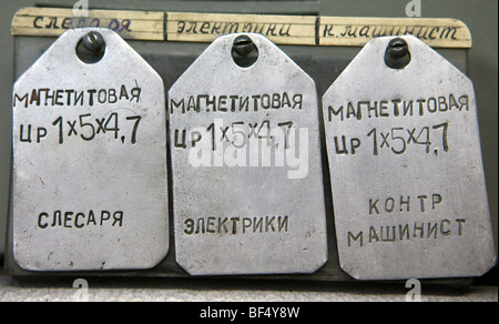 Drei silberne Tags mit russischen Wörtern und Zahlen in verlassenen Industriegebäude, Nahaufnahme, Detail, Russland Stockfoto