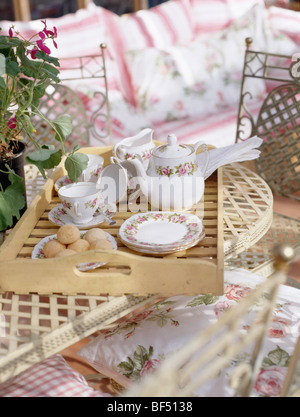 Nahaufnahme von floralen Teeservice auf Tablett aus Holz im Wintergarten Stockfoto