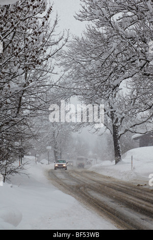 Starker Schneefall, Autos mit Licht fahren vorsichtig auf einer Straße, Reit Im Winkl, Bayern, Deutschland, Europa Stockfoto