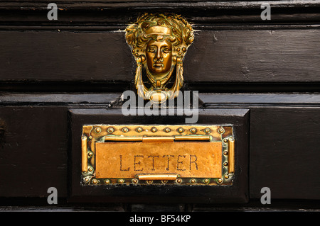 Frauenkopf als ein Türklopfer und ein Briefkasten aus Messing gefertigt auf einem Haus Tür, Lichfield, England, Vereinigtes Königreich, Europa Stockfoto