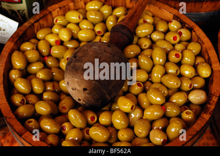 Grüne Oliven gefüllt mit Paprika in einer hölzernen Wanne mit einem hölzernen Schöpflöffel, Borough Market, 8 Southwark Street, London, England, Un Stockfoto