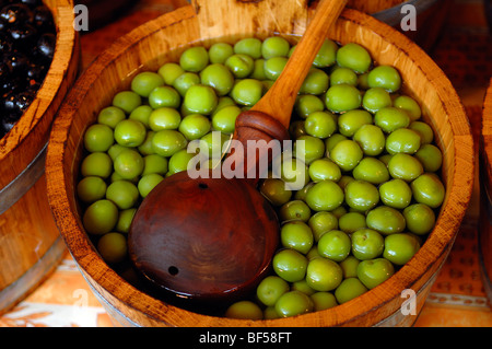 Grüne Oliven in einer hölzernen Wanne mit einem hölzernen Schöpflöffel, Borough Market, 8 Southwark Street, London, England, Vereinigtes Königreich, Europa Stockfoto