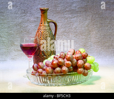 Stillleben mit einer Ton-Flasche, Trauben und einem Glas auf eine Leinwand-Hintergrund Stockfoto