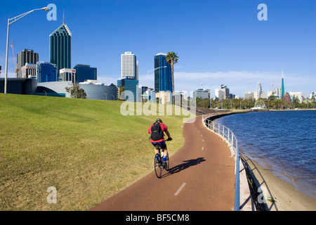 Mann, Radfahren auf einem Radweg in Richtung der Stadt. Perth, Australien Stockfoto