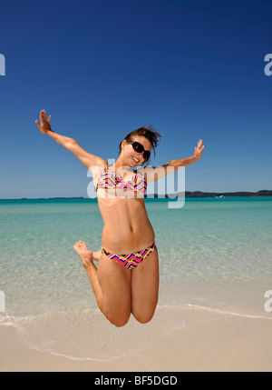 Springen Sie in die Luft, eine junge Frau am Meer, symbolisches Bild für Vitalität, Whitehaven Beach, Whitsunday Island, Whitsunday Isl Stockfoto