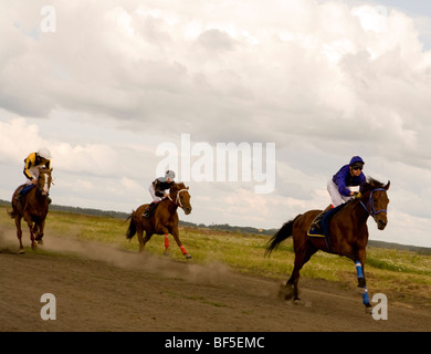 Jockeys gallopieren auf Rennstrecke am Pferd Rennen, Ural, Russland Stockfoto