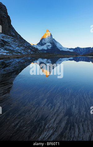 Matterhorn bei Sonnenaufgang im Winter mit Reflexion im Riffelsee, Zermatt, Wallis, Schweiz, Europa Stockfoto