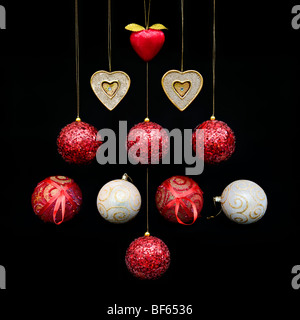 Modernes Bild von gemischten rot und gold Weihnachtsschmuck und Kugeln geformt ein Weihnachtsbaum Design auf schwarzem Hintergrund Stockfoto
