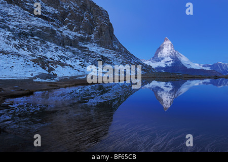 Matterhorn bei Sonnenaufgang im Winter mit Reflexion im Riffelsee, Zermatt, Wallis, Schweiz, Europa Stockfoto