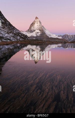 Matterhorn bei Sonnenaufgang im Winter mit Reflexion im Riffelsee, Zermatt, Wallis, Schweiz, Europa Stockfoto