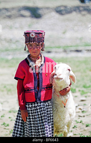 Tadschikistan-Mädchen in traditioneller Tracht mit Schafen, Artux, Xinjiang Uyghur autonome Region, China Stockfoto