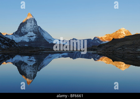 Matterhorn bei Sonnenaufgang im Winter mit Reflexion im Riffelsee, Zermatt, Wallis, Schweiz, Europa Stockfoto