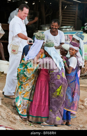 Western touristische Indische weibliche Straßenarbeiter, die ein digitales Foto. Puttaparthi, Andhra Pradesh, Indien Stockfoto