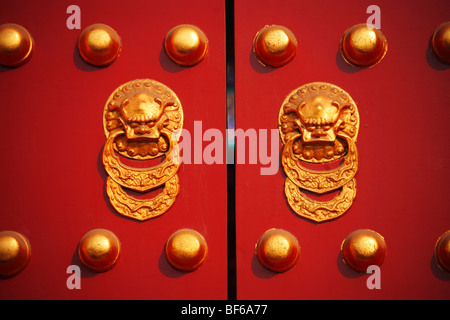 Gold vergoldet Türgriff und Tür Nägel auf große rote Tür in der verbotenen Stadt, Peking, China Stockfoto