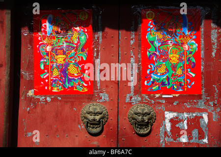 Verblasste rote Tür Hutong Hofhaus dekoriert mit Tuer-Goettern, Peking, China Stockfoto