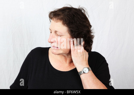 50er Jahre 60er Jahre Frau hält reiben poking Ohr Schmerzen Schmerzen hören Verlust Taubheit schmerzende Ohr leiden Stockfoto