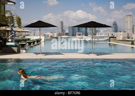 Frau, Schwimmen in einem Pool mit Blick auf Hafen in Hongkong Stockfoto