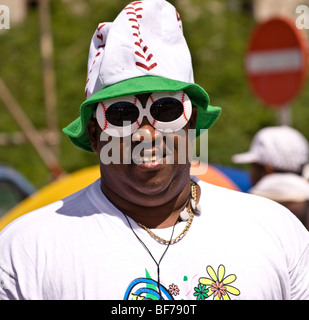 Mann trägt einen lustigen Hut und riesige Sonnenbrille verbindet den Spaß am Karneval, Curacao Stockfoto