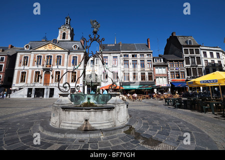 Li Bassinia Brunnen auf der Grand Place mit dem Rathaus und Cafés. Stockfoto
