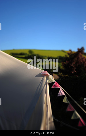 eine Leinwand-Zelt am späten Nachmittag mit einem blauen Himmel dahinter in einem Garten in Devon, UK, mit Girlanden auf die Abspannseile abgebildet. Stockfoto