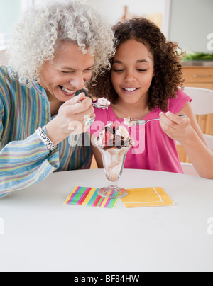 Großmutter und Enkelin teilen Eisbecher Stockfoto