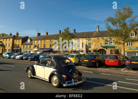 VW Käfer fahren entlang der High Street in Moreton-in-Marsh Gloucestershire, England Stockfoto