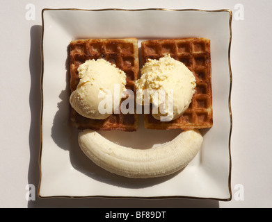 Banane und cornish Eis auf getoasteten Waffeln - Konzept der Smiley mit zwei Augen und einem Lächeln auf weißem Hintergrund Stockfoto