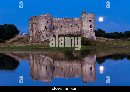 Der Mond hinter Carew Castle am Flussufer Carew Carew, Pembrokeshire, Wales Stockfoto