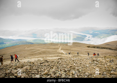 Wanderer auf dem Bergpfad auf dem Ben Nevis, dem höchsten Berg Großbritanniens, mit Loch aber und Loch Eil in der Ferne. Schottland Stockfoto