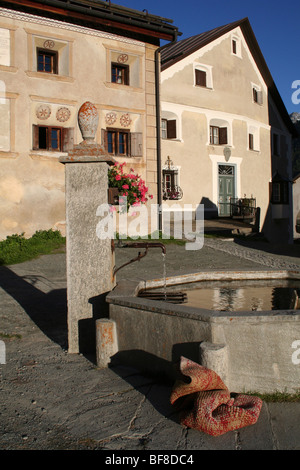 Wasserpumpe und Häuser im Zentrum von Guarda, ein malerisches kleines Dorf im Engadin Tal, Schweiz Stockfoto