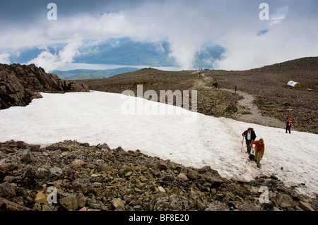 Schnee in der Nähe des Gipfels von Ben Nevis, dem höchsten Berg Großbritanniens mit Loch Eil in der Ferne. Schottland. Stockfoto