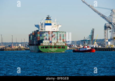 Ein Schlepper zieht ein Containerschiff heraus in die Elliott Bay am Hafen von Seattle, Seattle, WA, USA. Stockfoto