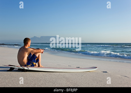 Surfer am Strand von Bloubergstrand mit dem Tafelberg im Hintergrund. Kapstadt-Südafrika Stockfoto