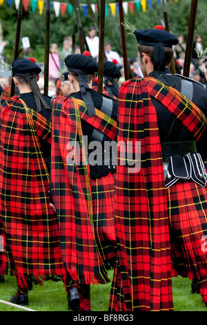 Die stolzen Marchers der Schottischen Lonach Highlanders, trug Wallace red tartan plaid, die Teilnahme an den Highland Games in Donside Lonarch, Schottland, Großbritannien Stockfoto