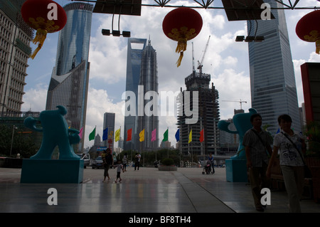 Blick auf Pudong Wolkenkratzer vom Eingang des Oriental Pearl Tower, flankiert von zwei Maskottchen der EXPO 2010. Shanghai, China. Stockfoto