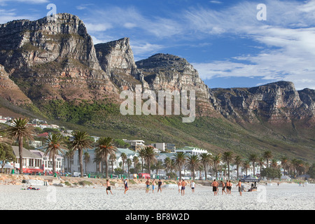 Fußball spielen auf Camps Bay Beach, Kapstadt, Südafrika. Stockfoto