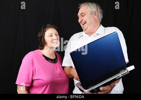 Ältere späten Mittleren Alter Ehepaar Surfen Internet zusammen mit Wireless-Laptop pc Computer zusammen mit silver Surfer Stockfoto