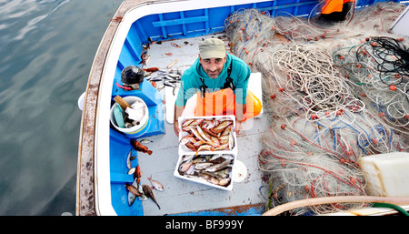 ein Fischer mit seinem mediterranen Fisch Fang Marktreife am Kai in Teulada, South West Sardinien, Italien Stockfoto