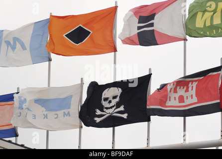 Der Jolly Roger, eine Piratenflagge, fliegt mit den maritimen Flaggen der Reedereien an ein Schiff gerade touristische Einrichtung Stockfoto