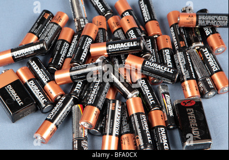 Ein Haufen von AA-Batterien gestapelt auf einem Tisch vor einem blauen Hintergrund aufgenommen. Gebrauchte Batterien bereit für das recycling. Stockfoto