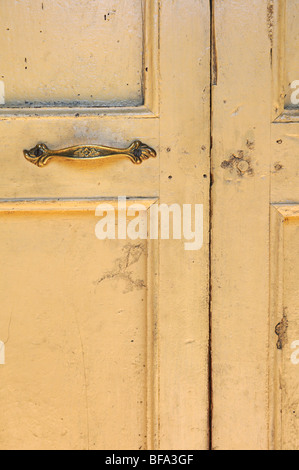 Alten Grunge gelbe Tür mit Bronze Türklinke Stockfoto