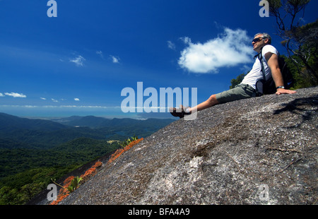 Wanderer ruht auf Kahlpahlim Felsen mit Blick auf die Küstenstadt Cairns, Lamm, Dinden National Park, Queensland, Australien Stockfoto