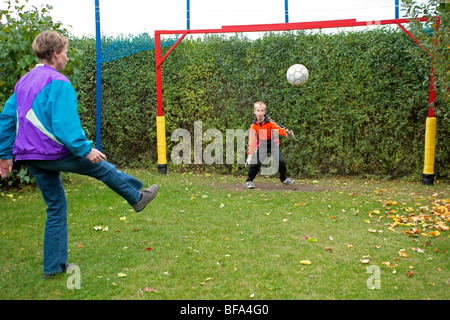 eine Mutter und ihr junger Sohn Fußball spielen Stockfoto