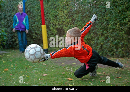 Fang einen Fußball, den seine Mutter gekickt hat junge Stockfoto