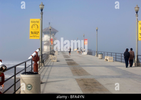 Jogger läuft am Huntington Beach Pier an einem nebligen Morgen. Stockfoto